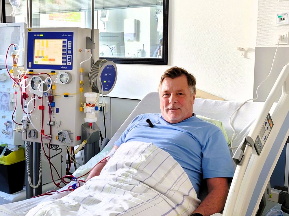 Ein CIDP-Patient sitzt lächelnd auf einem Krankenhausbett. Er ist an ein Gerät zur Blutreinigung angschlossen und erhält eine Immunadsorption.